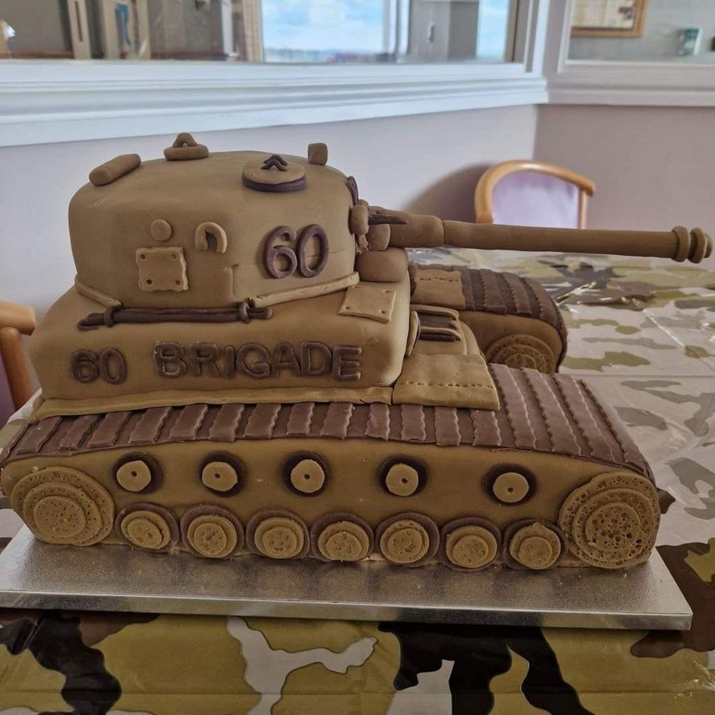 A cake in the shape of a tank with the number 60 on it