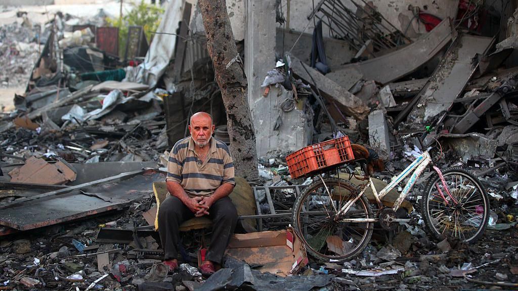 A Palestinian man rests amid debris at the site of an Israeli strike on a house in Gaza City, on July 30, 2026.