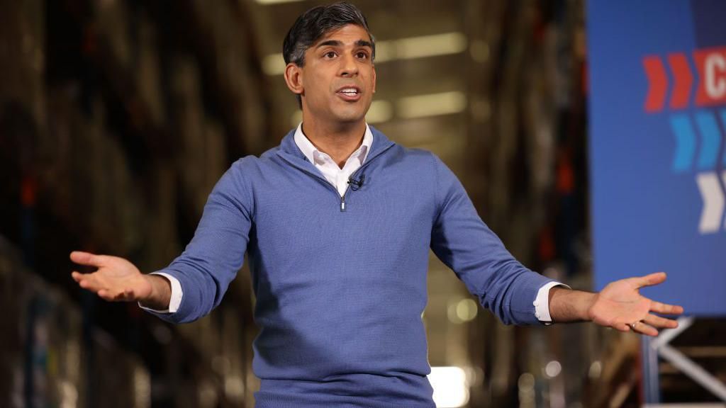 Rishi Sunak holds his hands open while campaigning in the general election