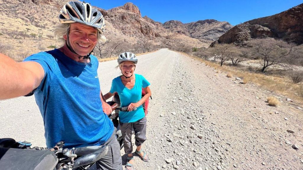 Dave and Helen take a selfie on their bike in a desert