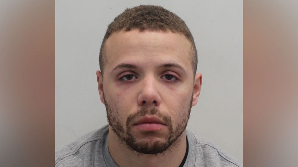 Mugshot of a  man with a beard and short hair wearing a grey jumper