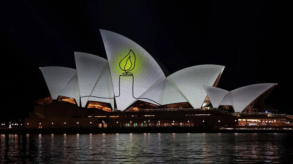 Candle lit up on the Opera House sails