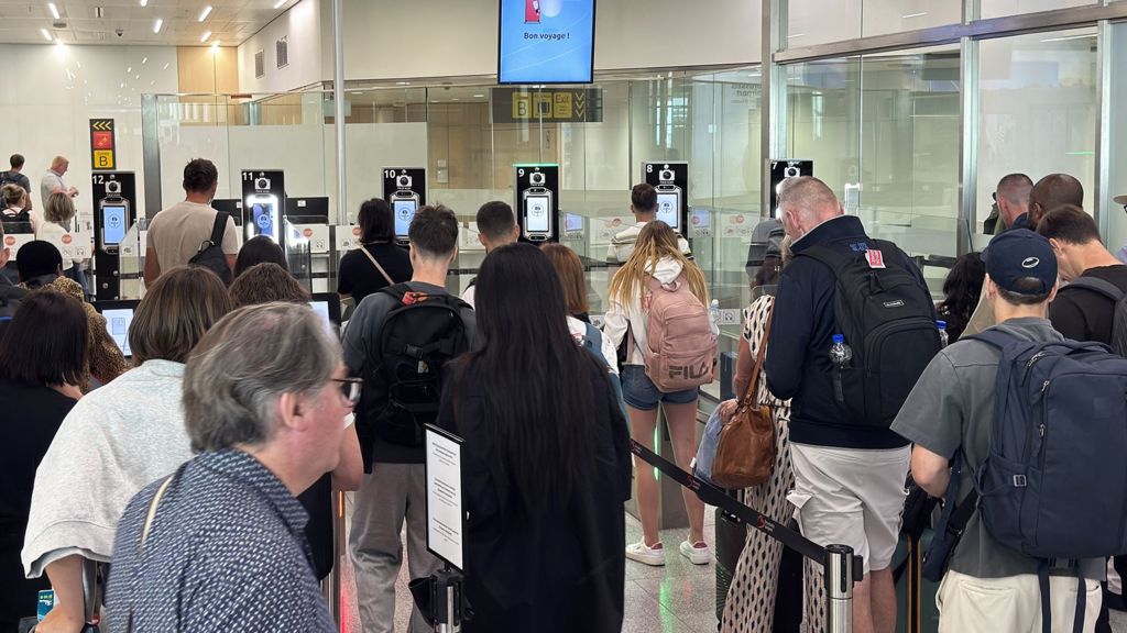 Passengers wait in long queues at passport control in the departures terminal of Brussels Airport in Brussels, Belgium, on June 29, 2026.