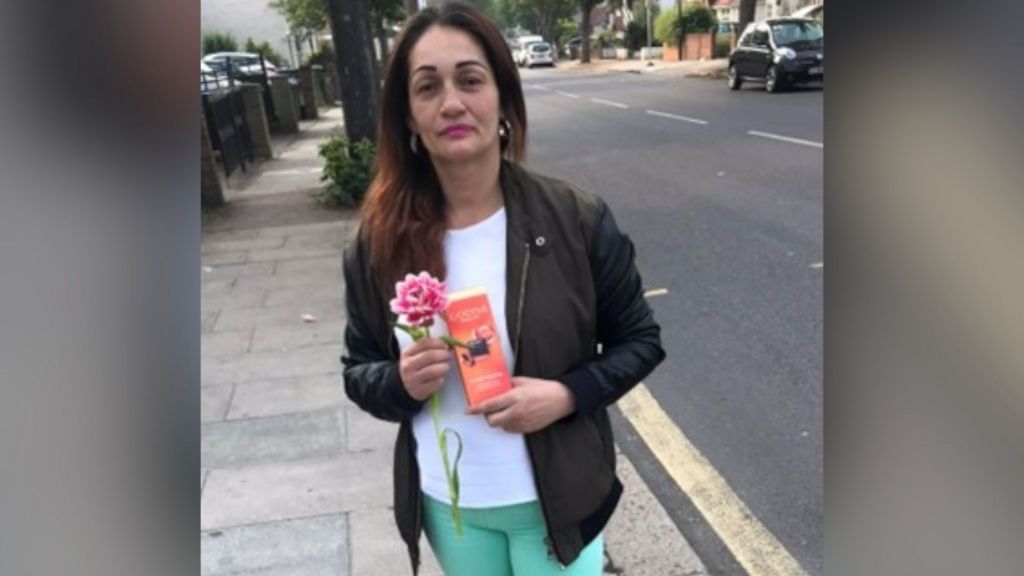 Carmenza Valencia-Trujillo holding a flower and an orange box