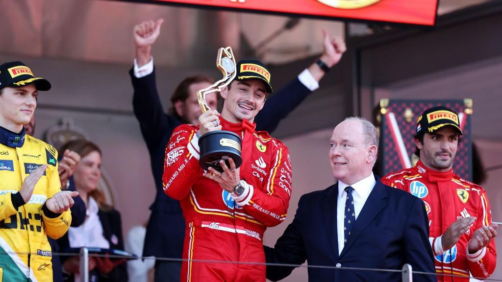 Charles Leclerc celebrates on the podium in Monaco
