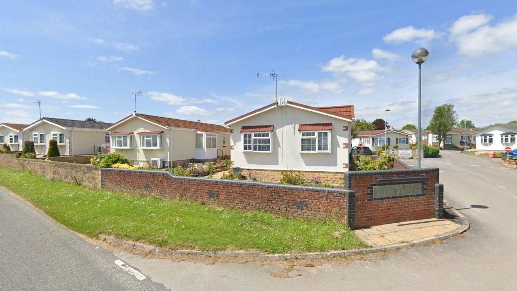 Part of Lillybrook Estate which shows white and cream homes behind a brick wall