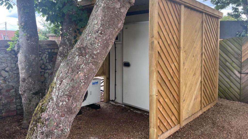 Large professional fridge in an open shed in yard