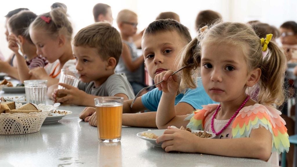 Children from a Ukrainian orphanage eat a meal at a camp in southwestern Russia