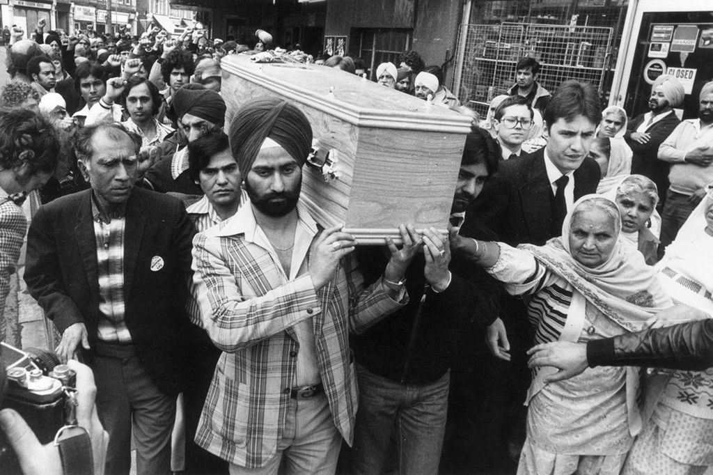 People carry the coffin of Blair Peach through the streets of London in 1979, with a large crowd following the procession