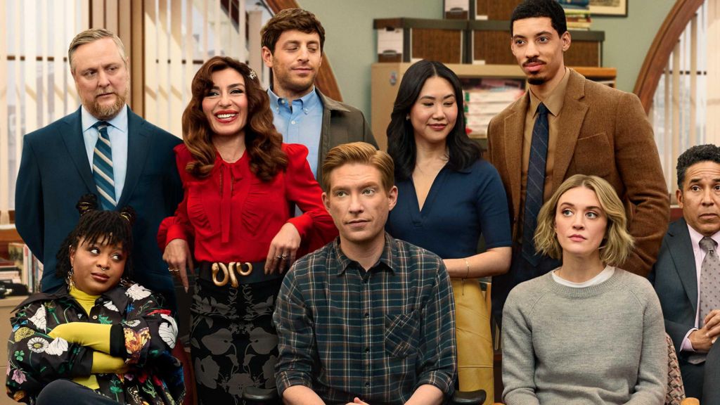 Cast of The Paper gathered together in a newsroom 