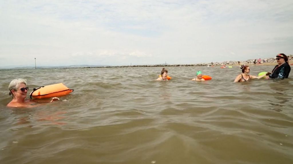 Group of people swimming in Morecambe bay