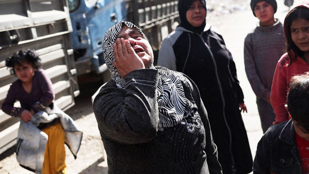 A woman holds her hand to her face in grief in the district of Tadamon in Damascus (file photo)