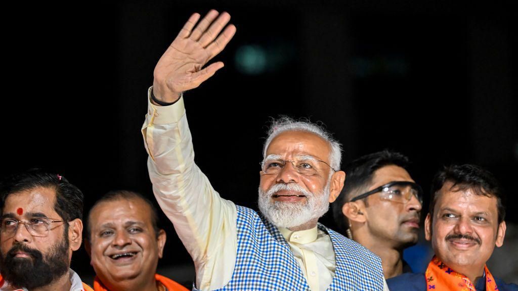India's Prime Minister and leader of the ruling Bharatiya Janata Party (BJP) Narendra Modi (C) with chief minister of Maharashtra state Eknath Shinde (L) and their deputy chief Minister Devendra Fadnavis (R) waves to the crowd during his roadshow in Mumbai on May 15, 2024, ahead of the fifth phase of voting of India's general election. (Photo by Punit PARANJPE / AFP) (Photo by PUNIT PARANJPEP