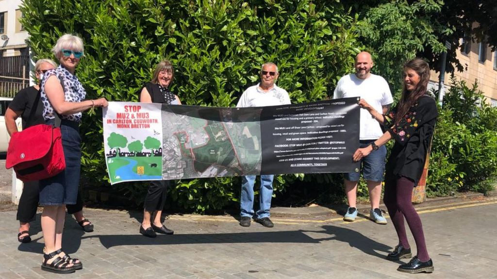 Campaigners against the project hold up a banner