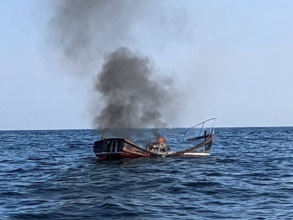 Burnt boat in sea