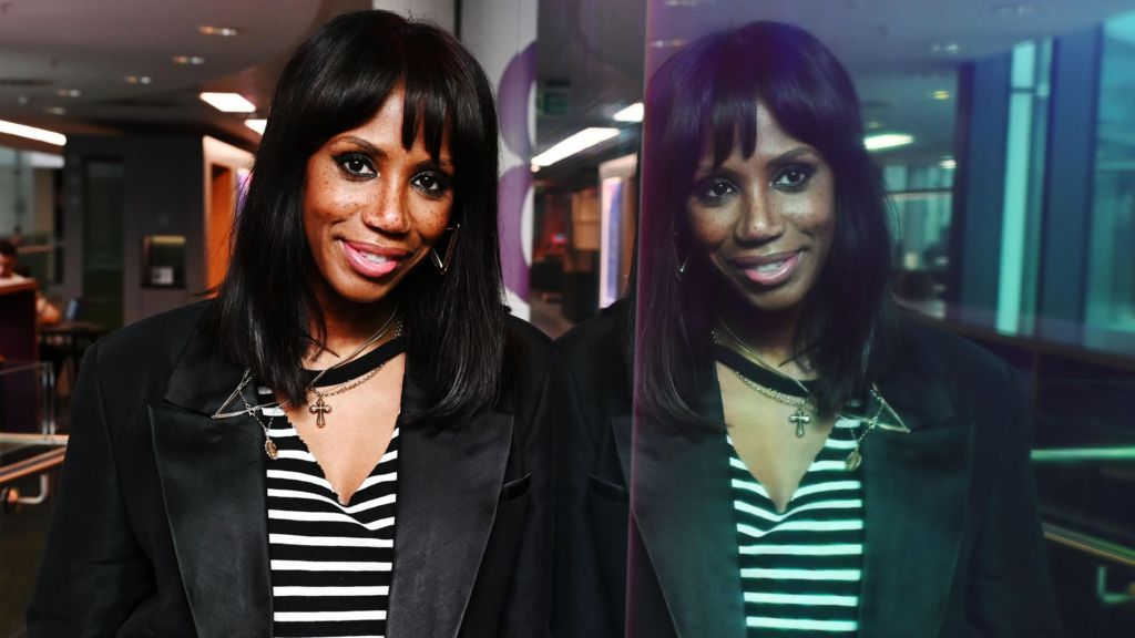 Shaznay Lewis poses at the BBC's New Broadcasting House, against a reflective surface showing her mirror image