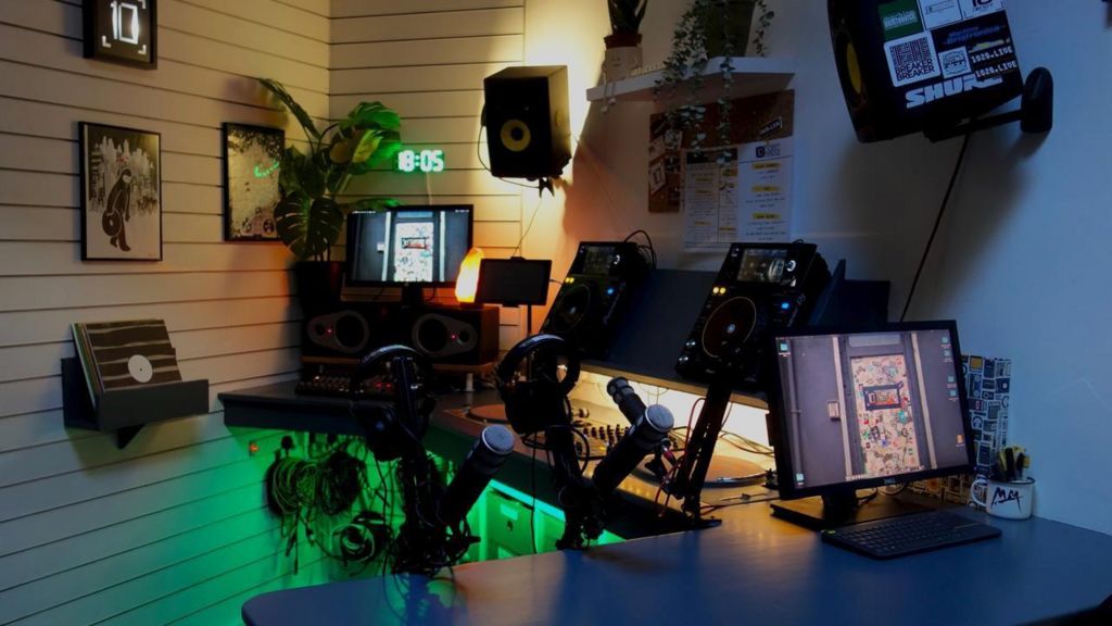 A radio studio set up with DJ decks,s epakers and computers
