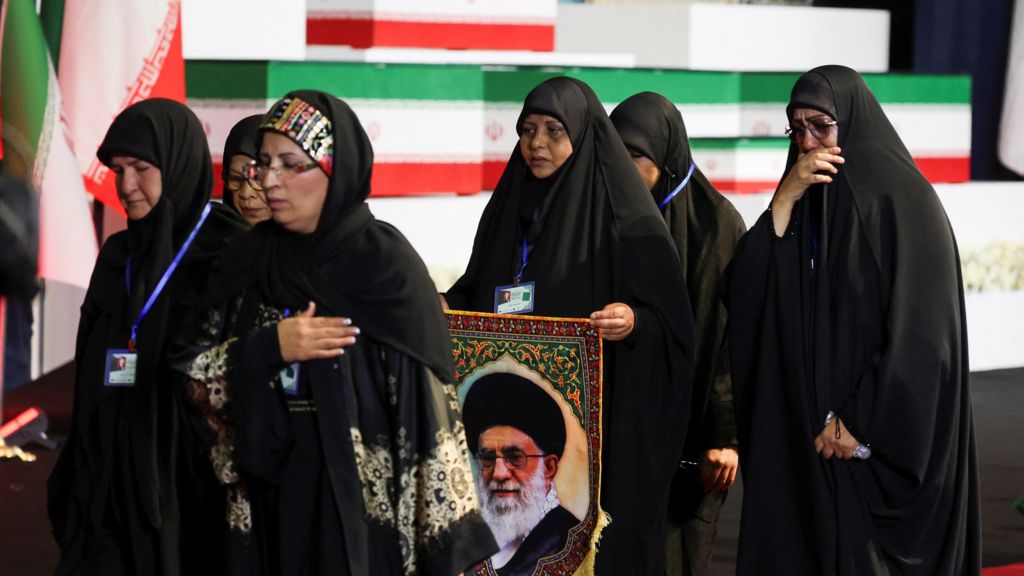 Women react near the coffins of Iran's late Supreme Leader Ayatollah Ali Khamenei and his family members.