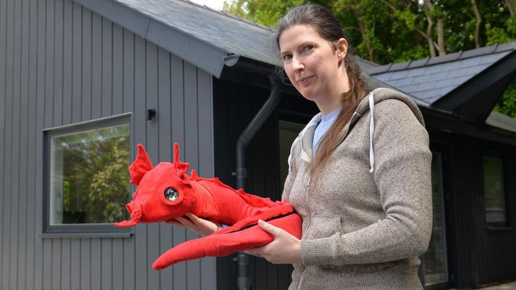 Dr Patricia Shaw with the robotic pet dragon outside Aberystwyth University's Smart Home Lab