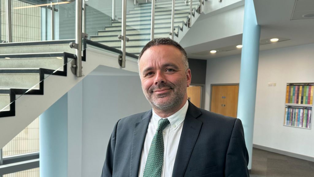 Jason Lancaster in a suit with a green tie