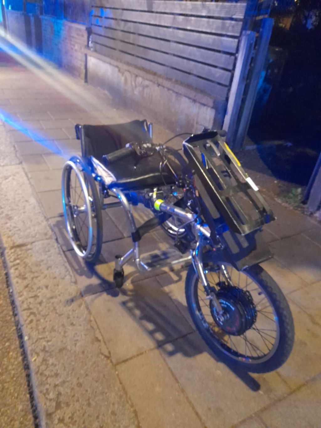 A wheelchair with an extra wheel attached to the front of it  