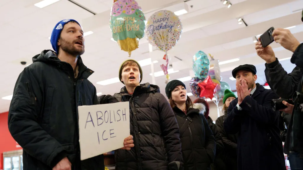 Protesters gather in a Target store, holding a sign reading 