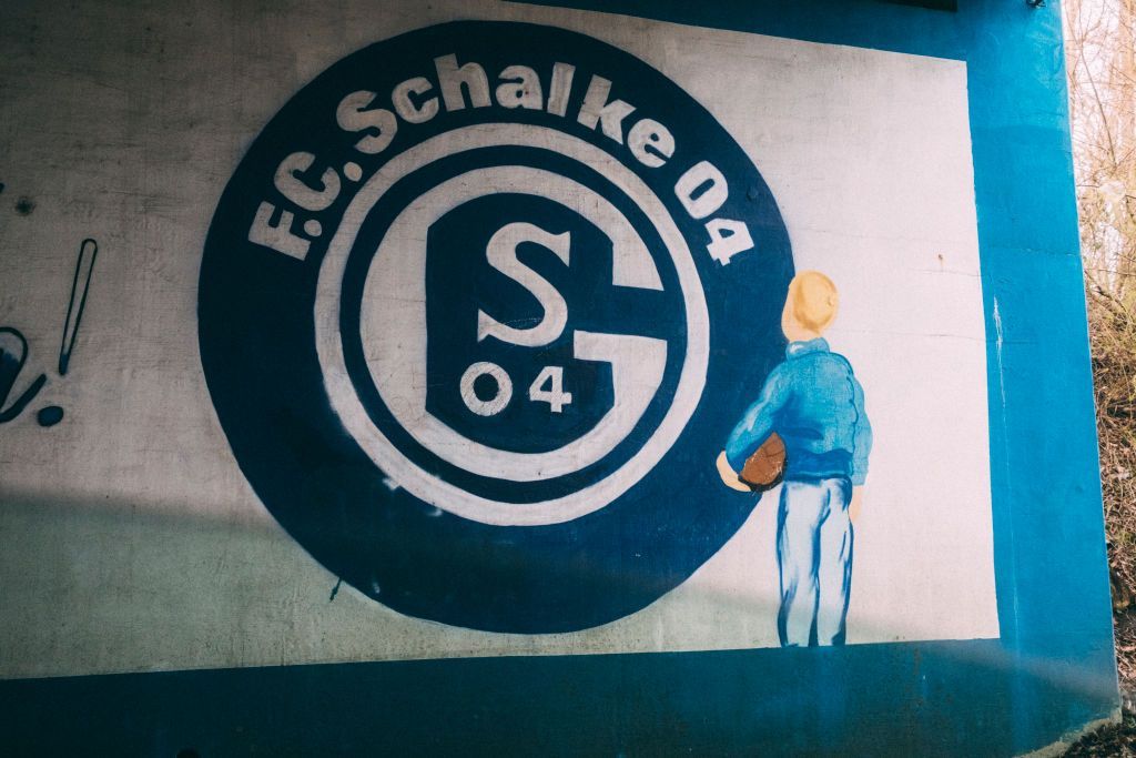 A mural of a boy looking at the Schalke badge