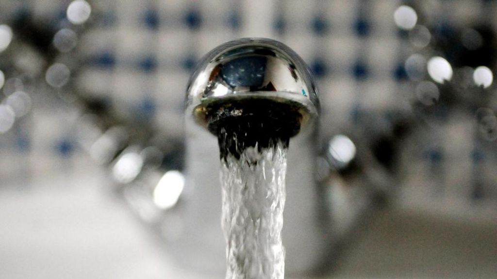 A bathroom tap with flowing water