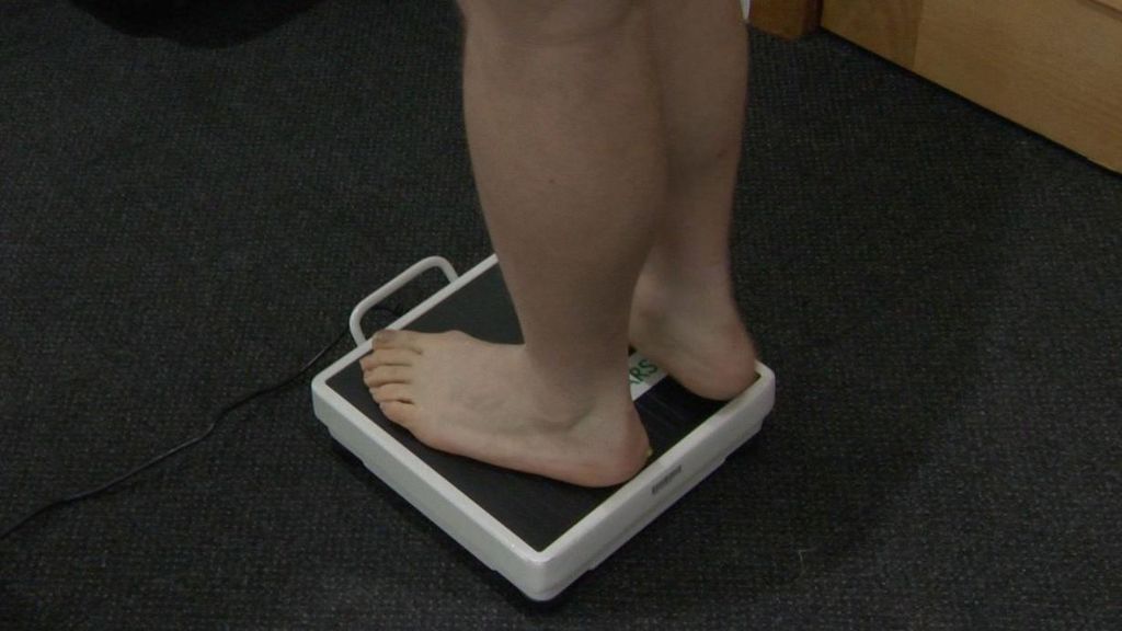 Man weighing himself on scales