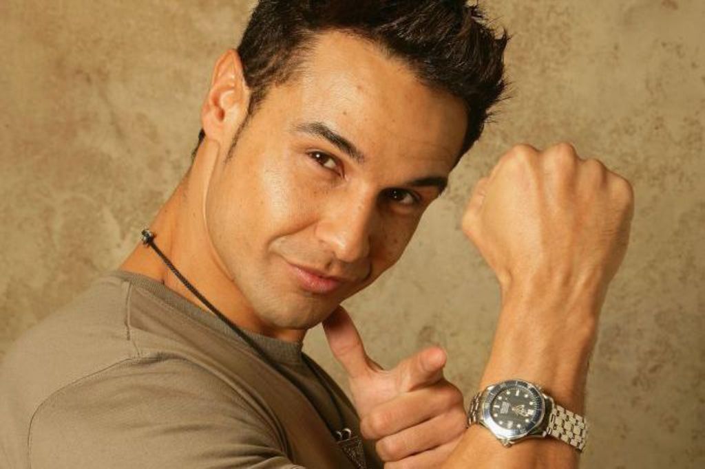 Chico Slimani poses for a portrait to celebrate of his debut single. He wears a watch and points at the camera