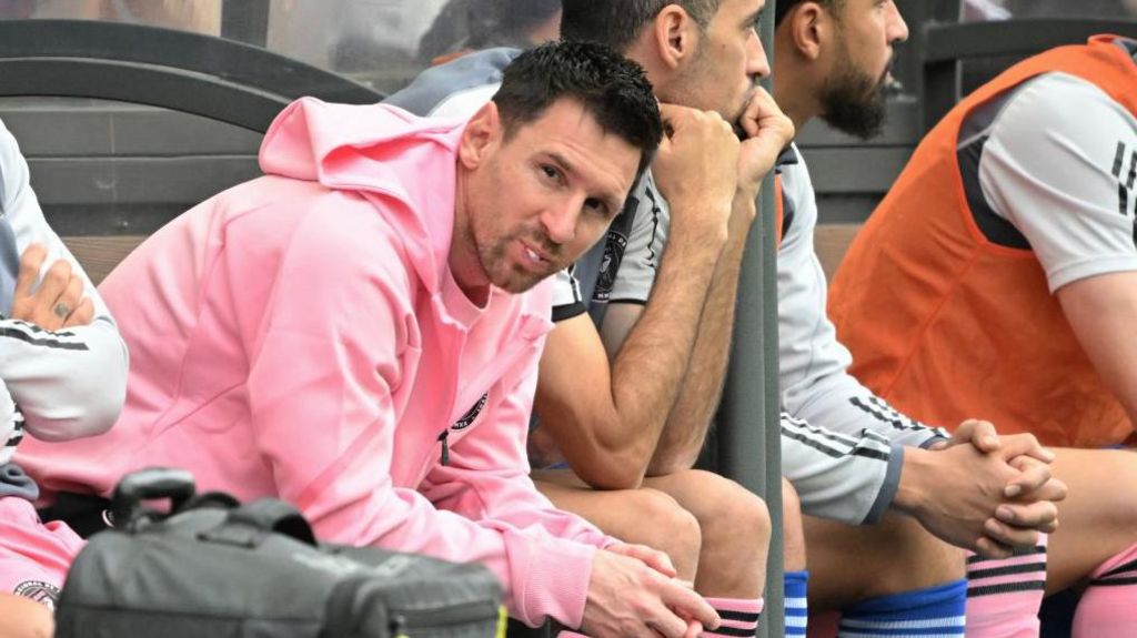 Lionel Messi sits on the bench, looking indifferent, while Inter Miami play a Hong Kong League XI