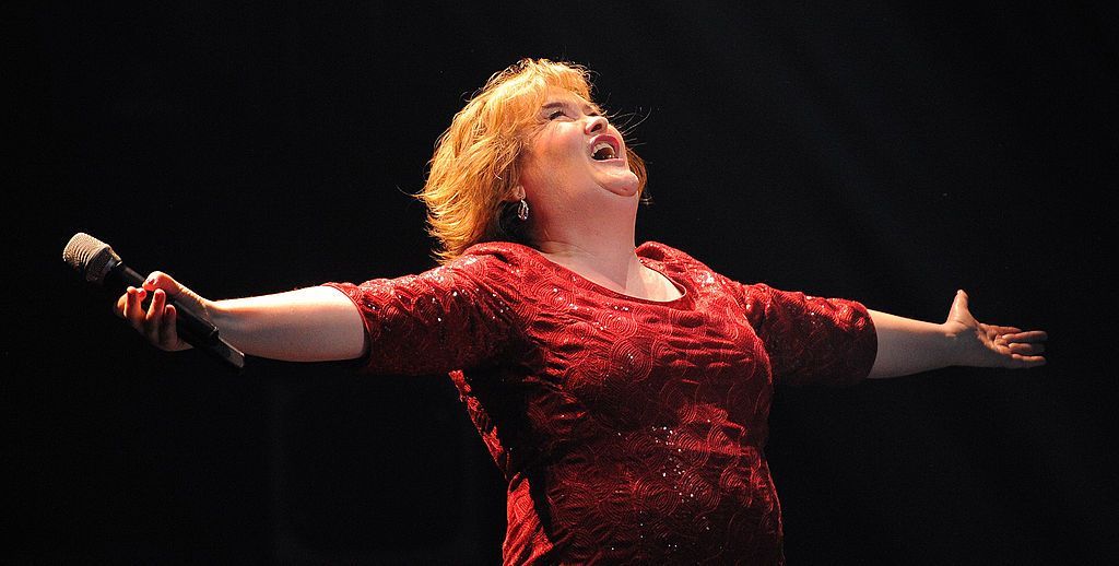 Susan Boyle, wearing a red dress with her arms outstretched, sings during the musical "I Dreamed A Dream" at the Royal Theatre in Newcastle in 2012