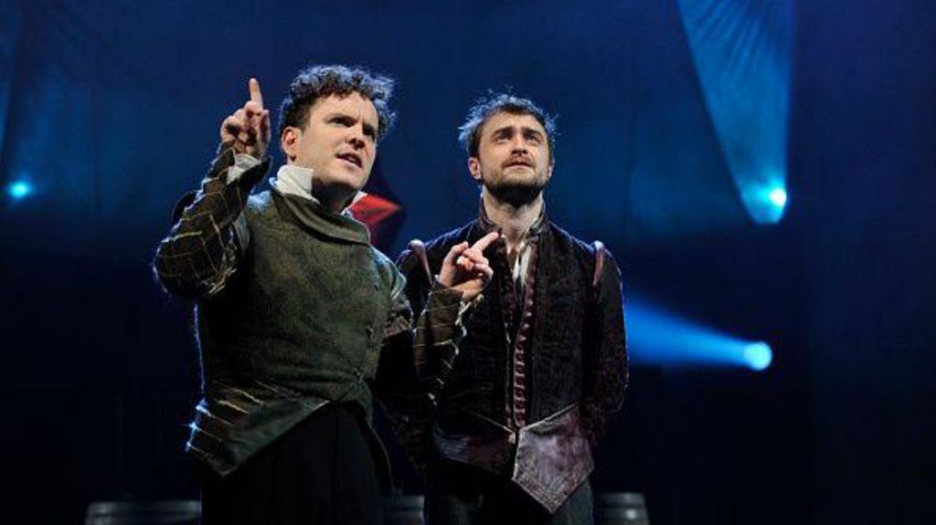 Two men in Elizabethan costume stand on stage.