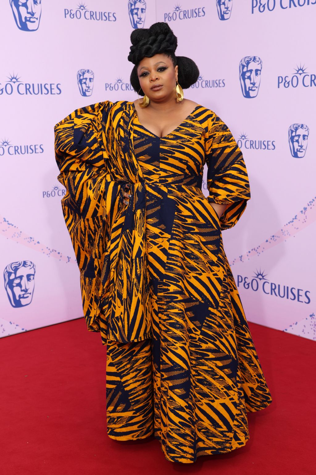 Gbemisola Ikumelo in a patterned orange and black dress