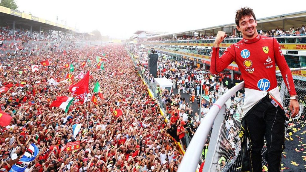 Charles Leclerc poses with Ferrari fans behind him