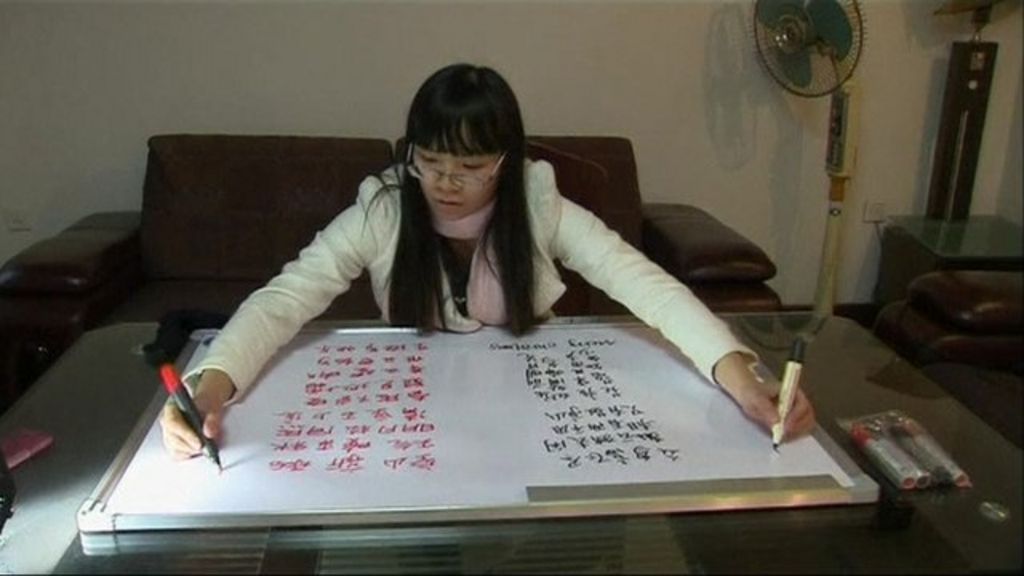 Two hands writing two different languages BBC News