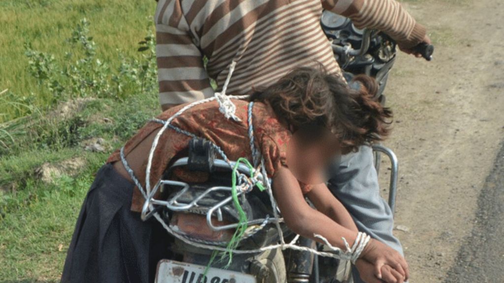 Indian man takes daughter to school roped to motorcycle - BBC News