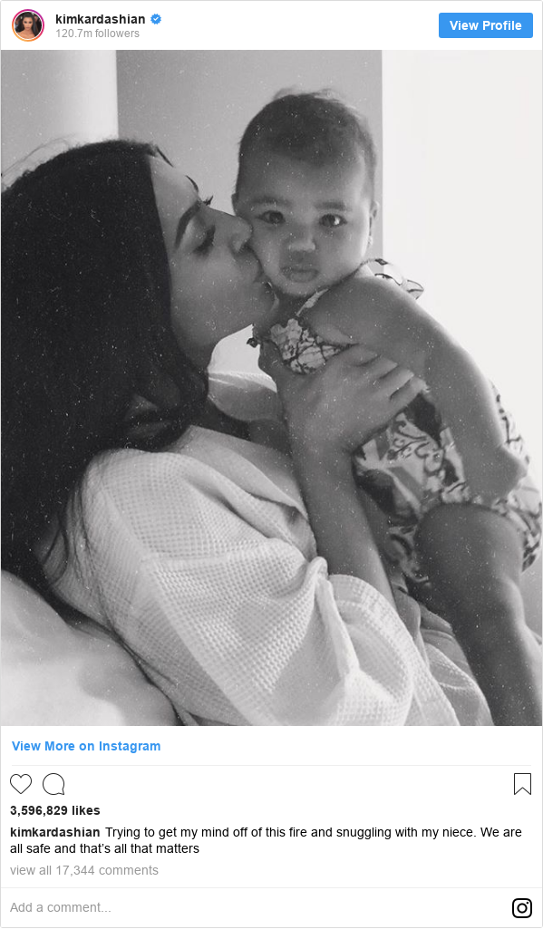 Instagram post by kimkardashian: Trying to get my mind off of this fire and snuggling with my niece. We are all safe and that’s all that matters