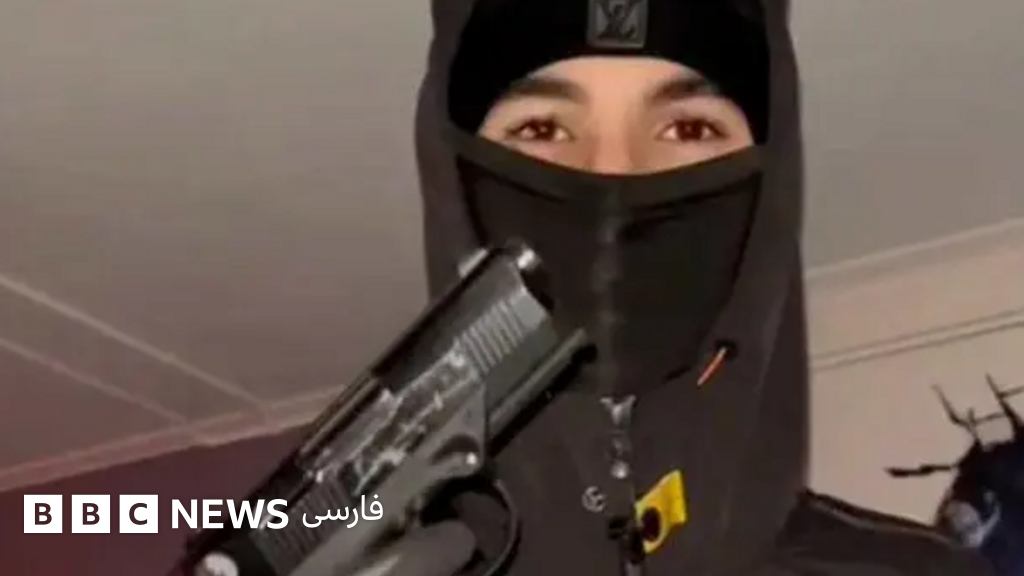 فردی که سر و چهرهاش پوشیده و تنها چشمهایش معلوم است، تپانچهای را در دست گرفته رو به دوربین نشان میدهد