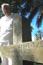 Swiss surgeon, Hans-Peter Muller, stands beside Albert Schweitzer's grave