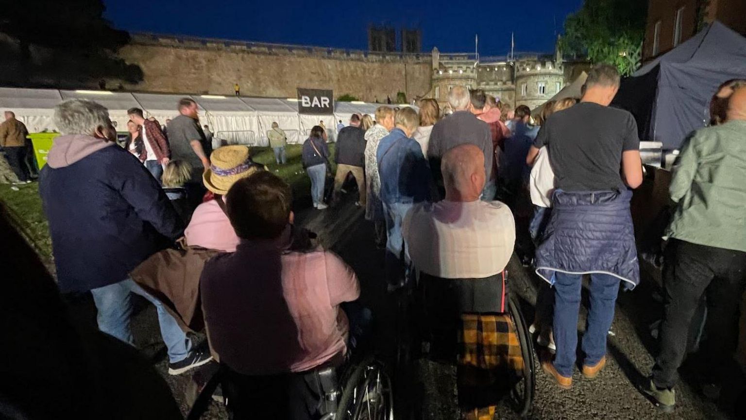 People in wheelchairs leaving Lincoln Castle via East Gate after the concert