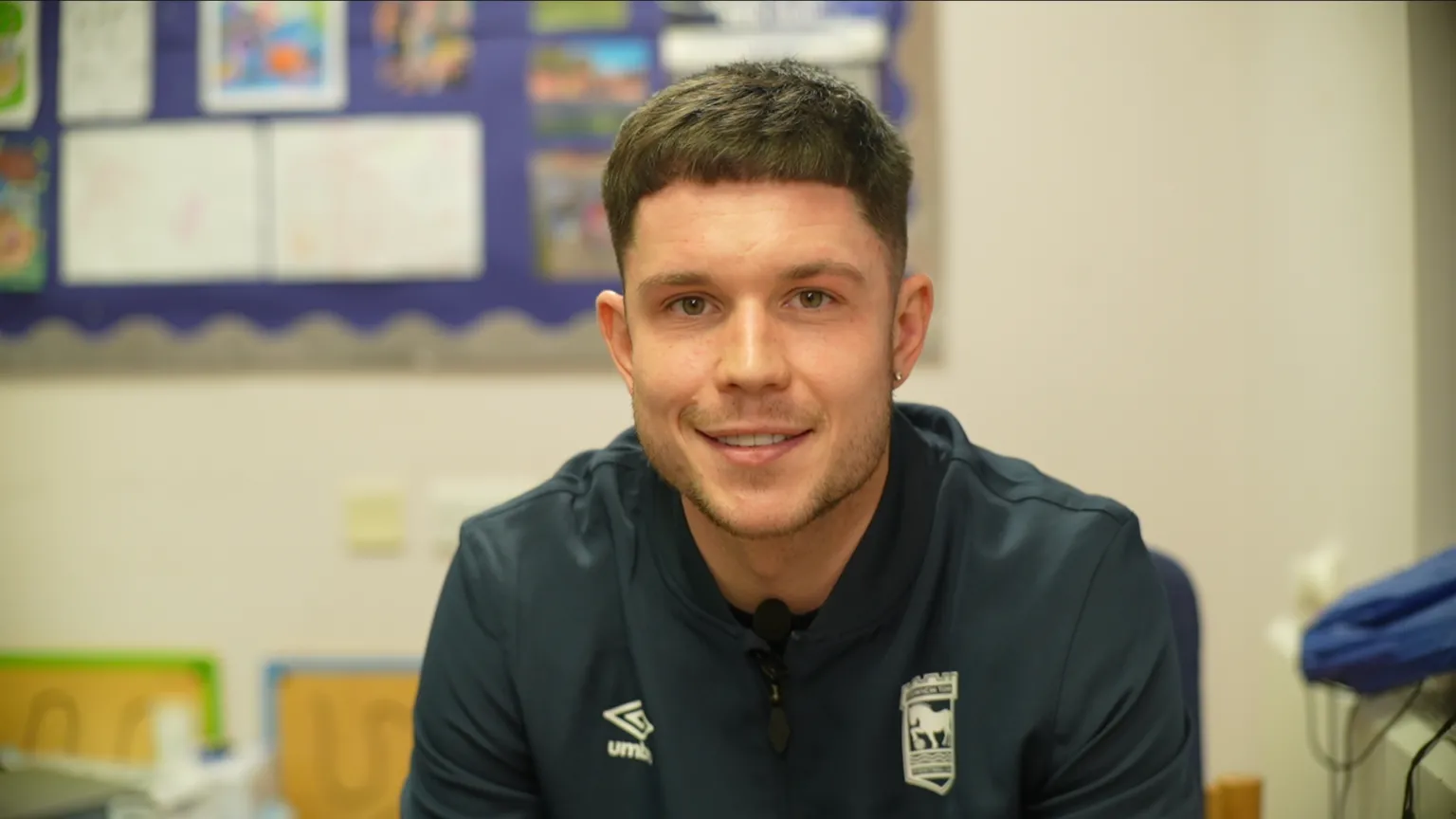 Ipswich Town player George Hirst sitting in a classroom.