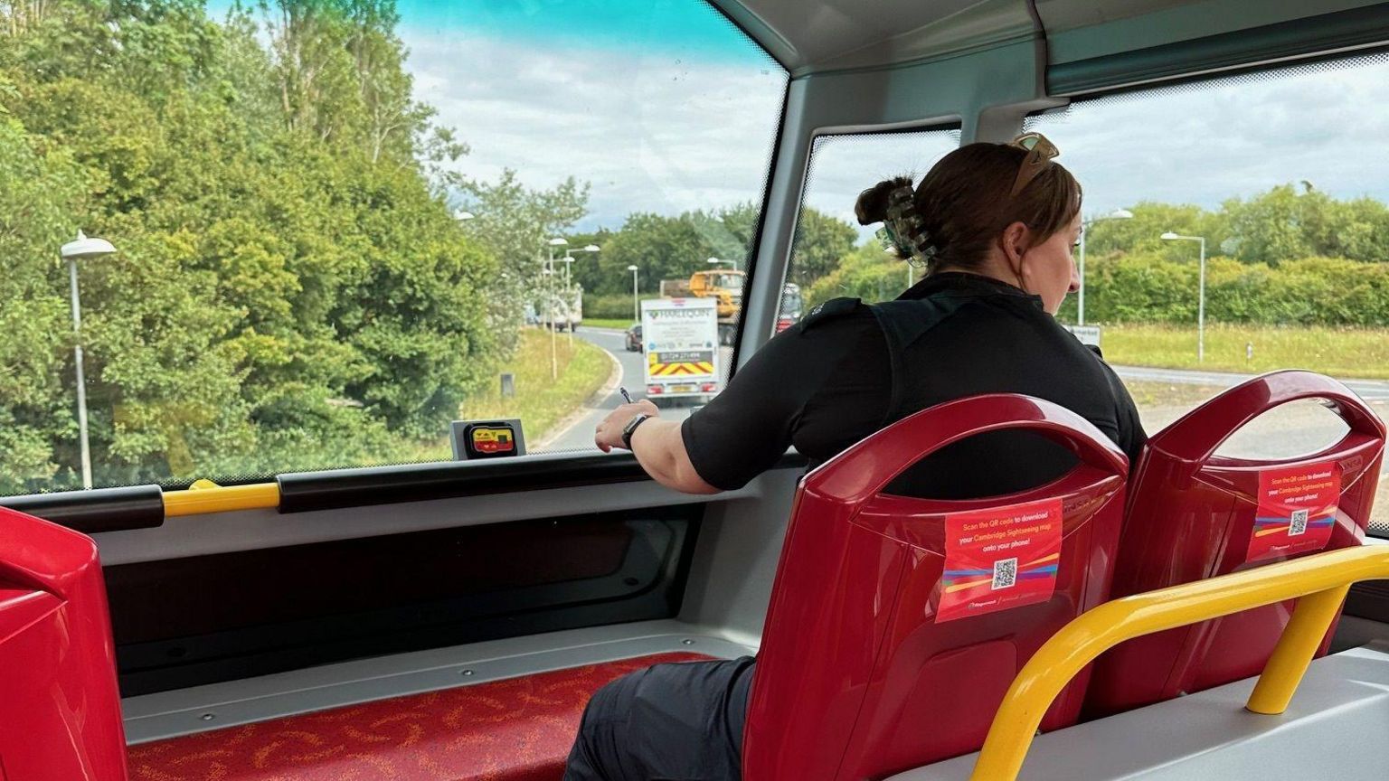 A police officer on the top deck of a bus in Cambridge