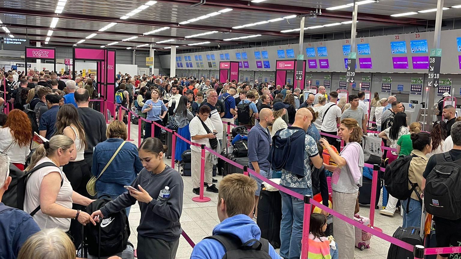 Passengers queue at Luton Airport