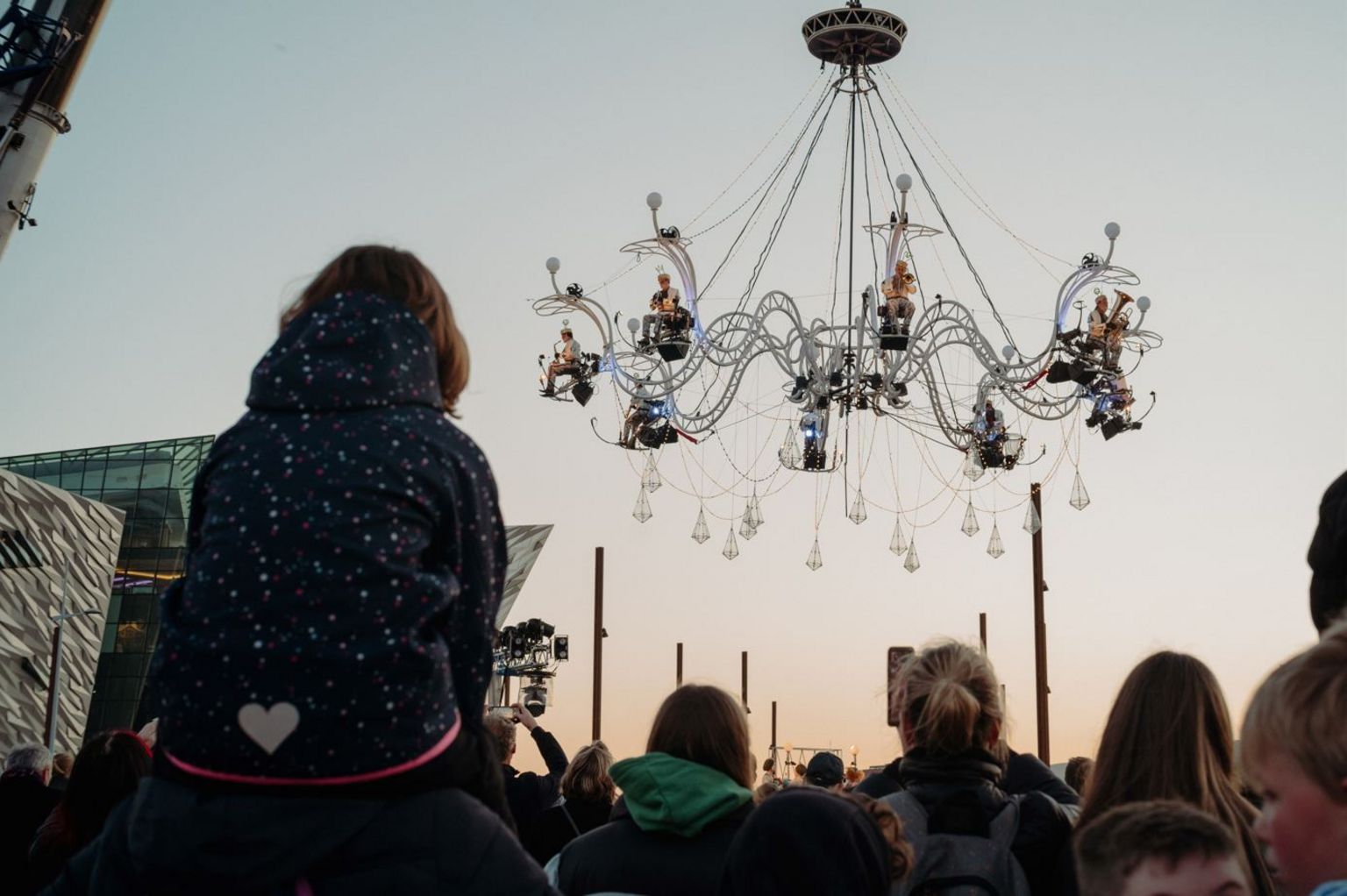 Crowd watching giant chandelier with orchestra performing