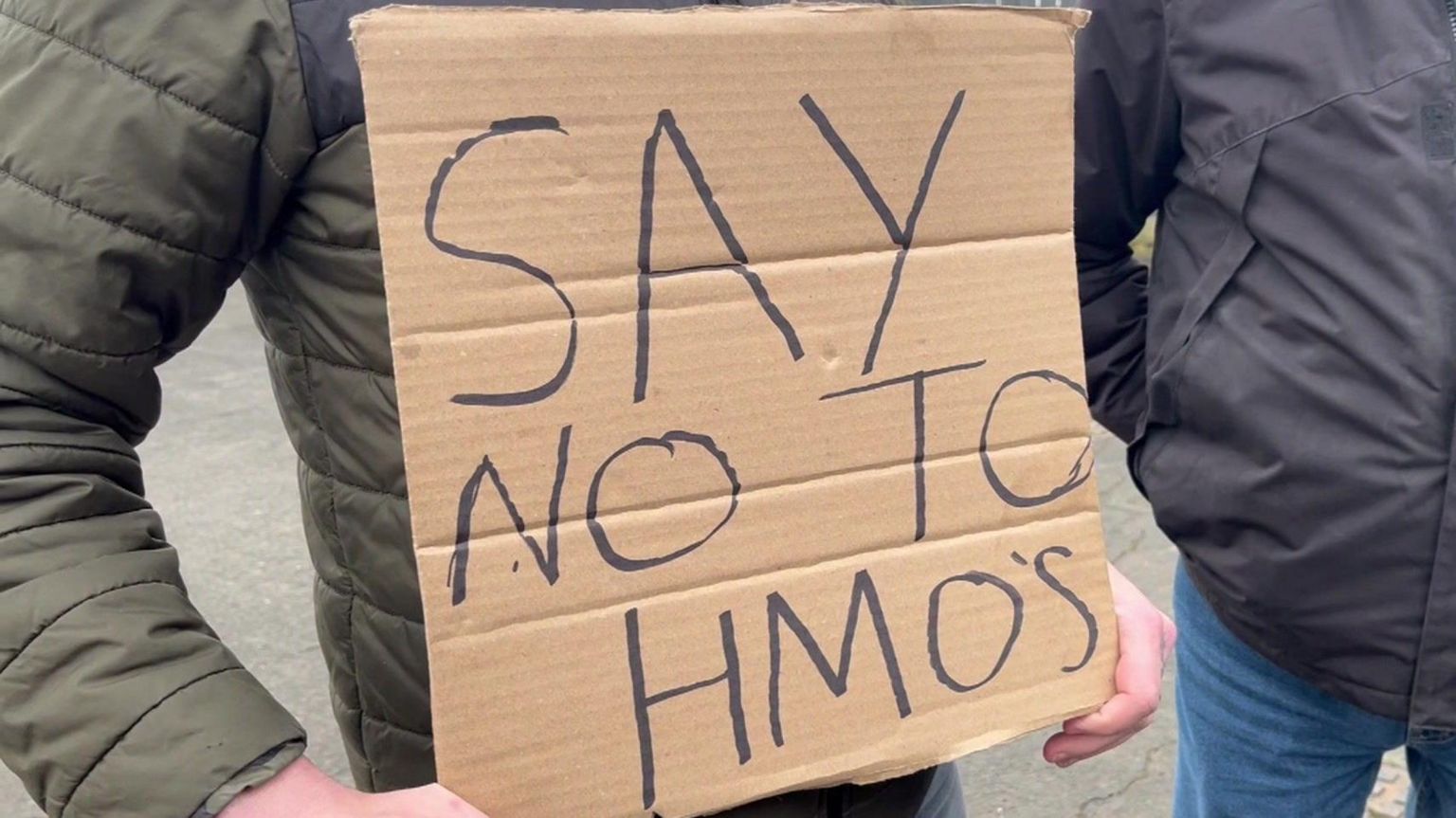 A campaigner holds a 'Say No To HMOs' sign