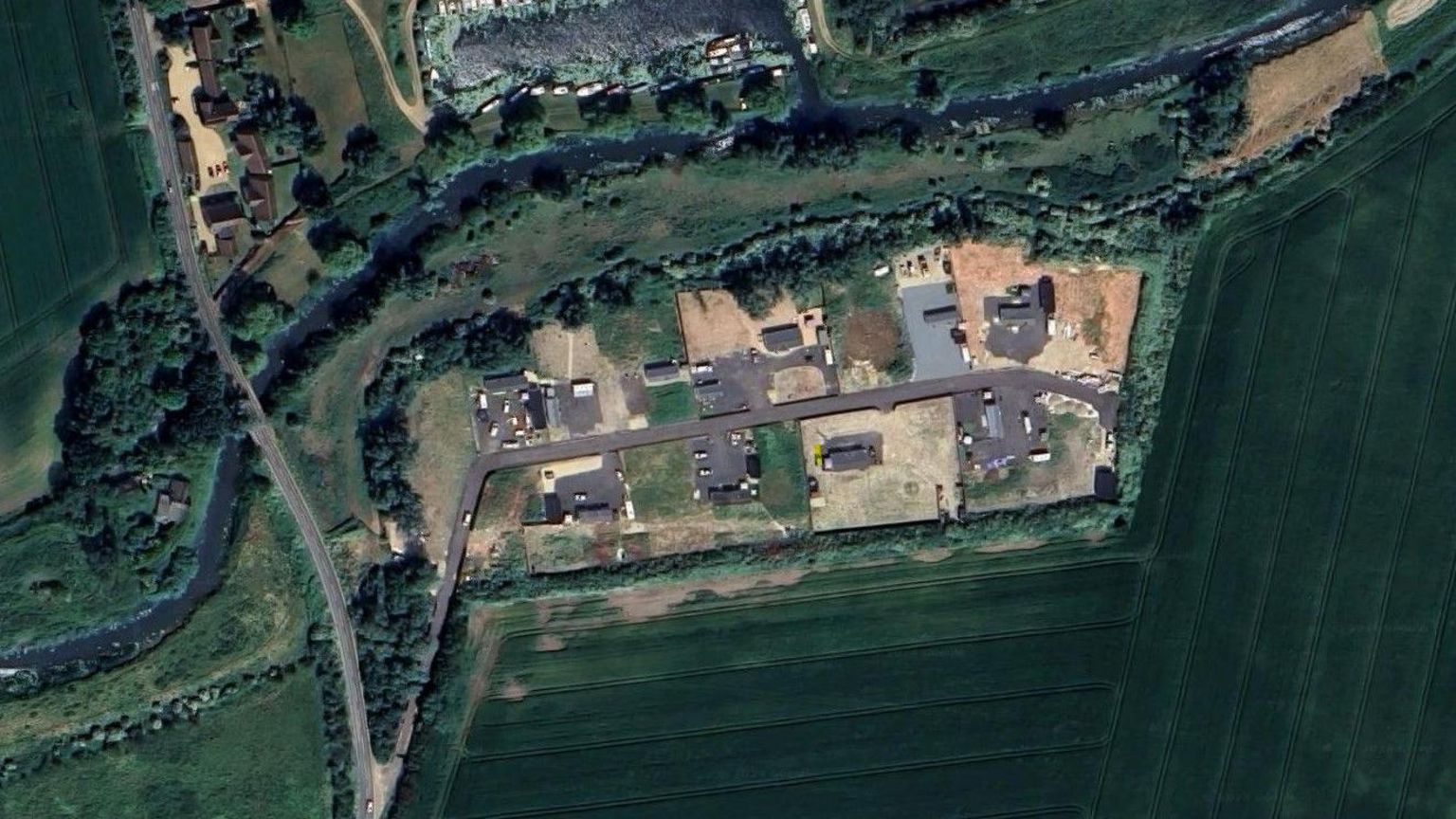 Aerial shot of land south of Chear Fen Boat Club, showing area of road and buildings in the centre surrounded by fields and trees