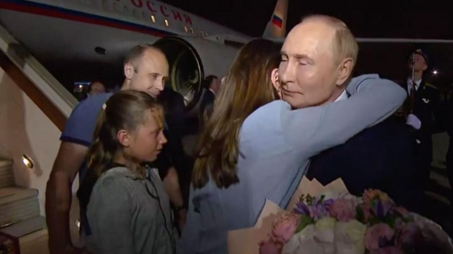 Russian President Vladimir Putin (R) welcomes prisoners released following the swap deal at Vnukovo International Airport in Moscow