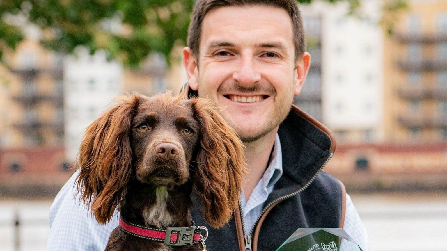 Bonnie, the cocker spaniel who won the public vote, with Conservative Member of the Senedd James Evans