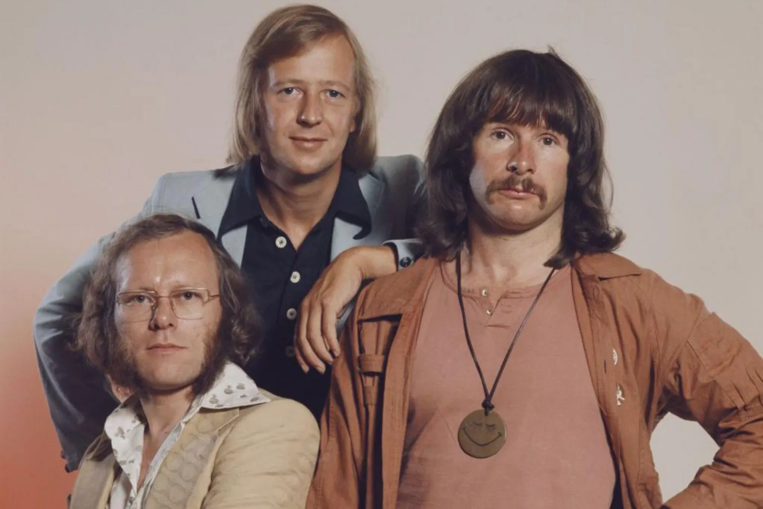 Hulton Archive via Getty Images The Goodies: (l to r) Graeme Garden, Tim Brooke-Taylor and Bill Oddie in 1975. Oddie has a prominent medallion around his neck. They are all staring rather blankly into the camera.